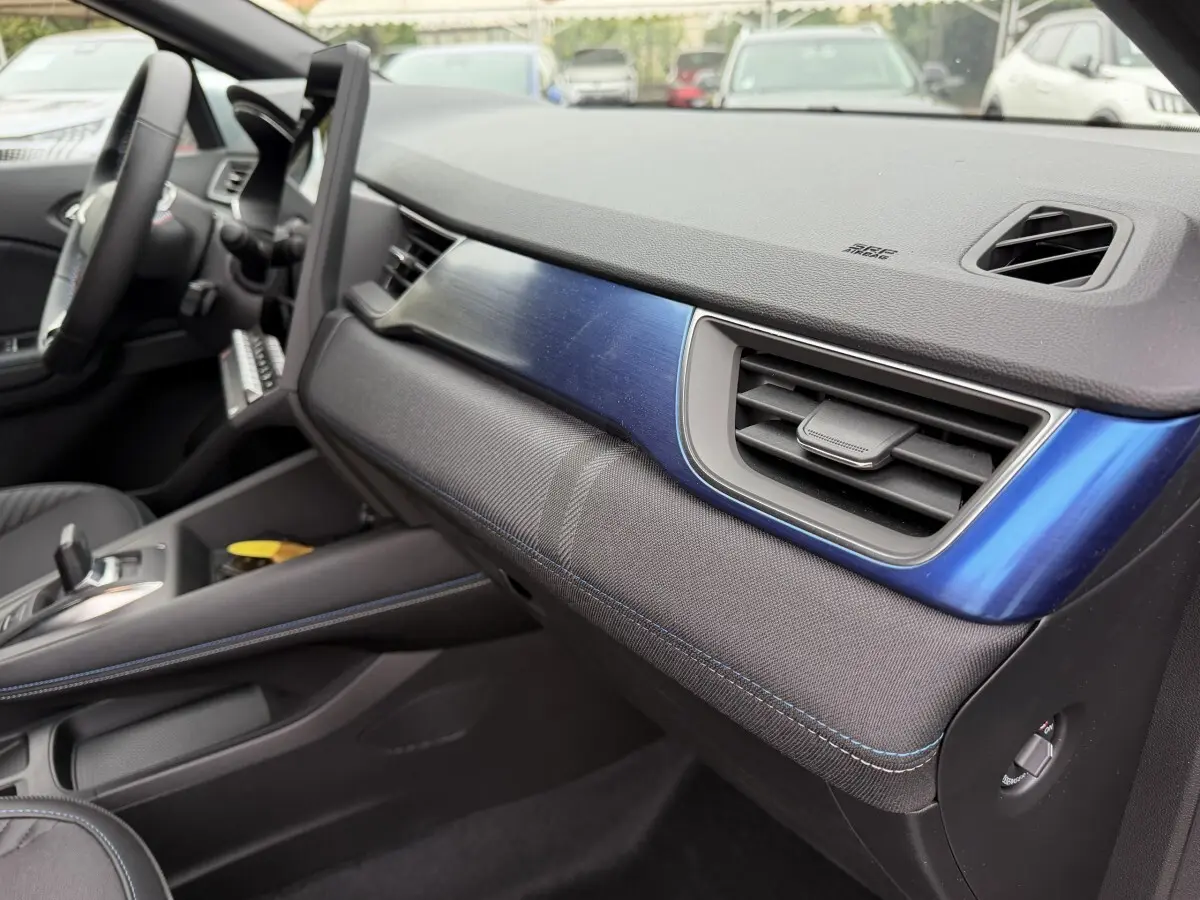 Vue intérieure côté passager du tableau de bord bleu et noir du Renault Captur Esprit Alpine hybride 2026.