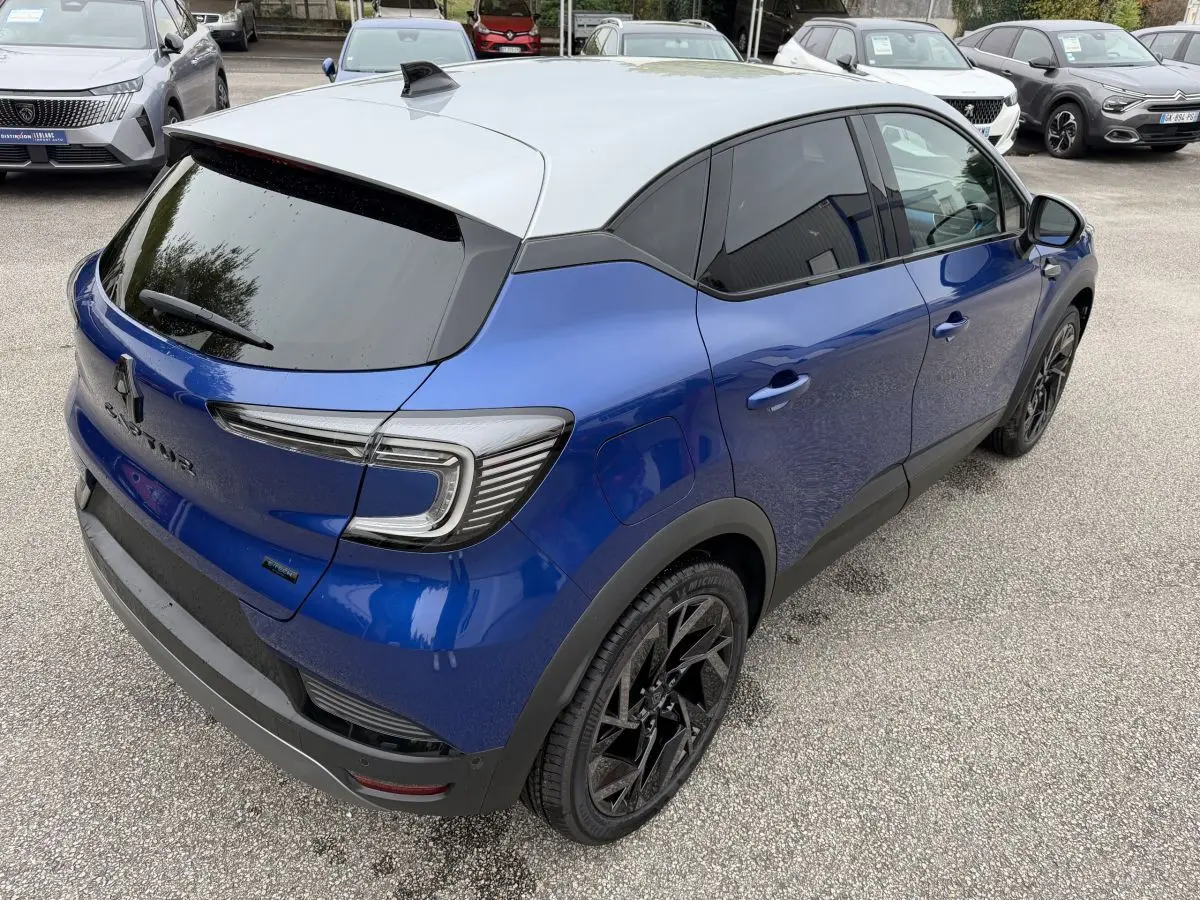 Vue 3/4 arrière droite du Renault Captur bleu esprit Alpine avec toit blanc et jantes noires distinctives.