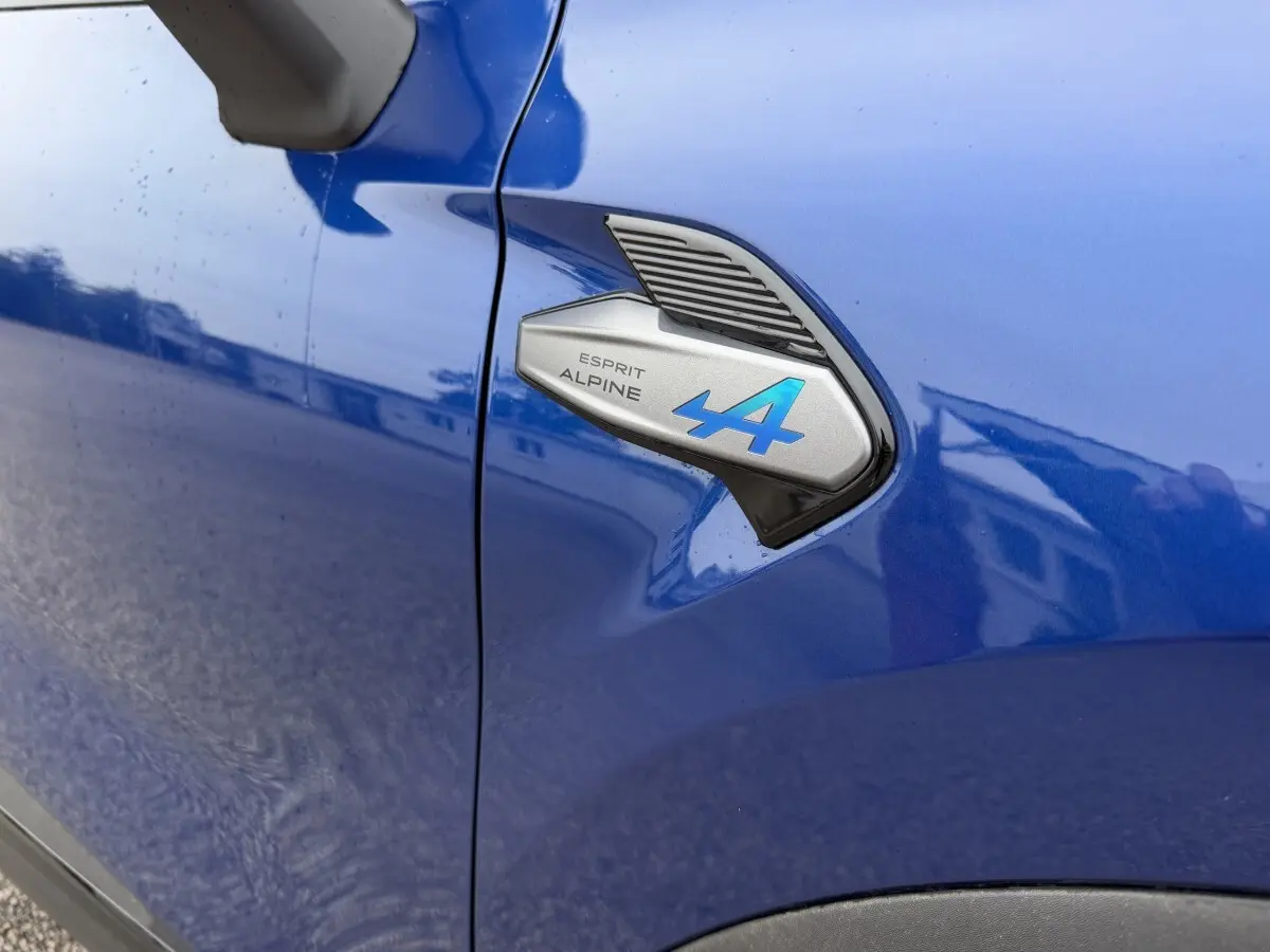 Détail du logo Esprit Alpine bleu sur l'aile avant gauche d'un Renault Captur bleu 2026.