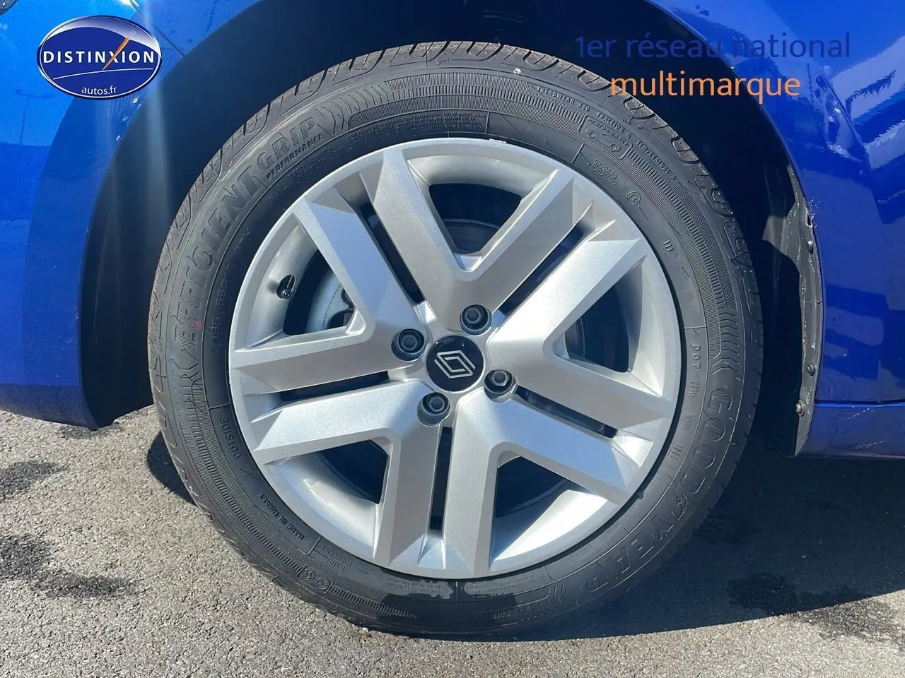 Gros plan sur la roue avant gauche avec enjoliveur argenté d'une Renault Clio V bleu iron.