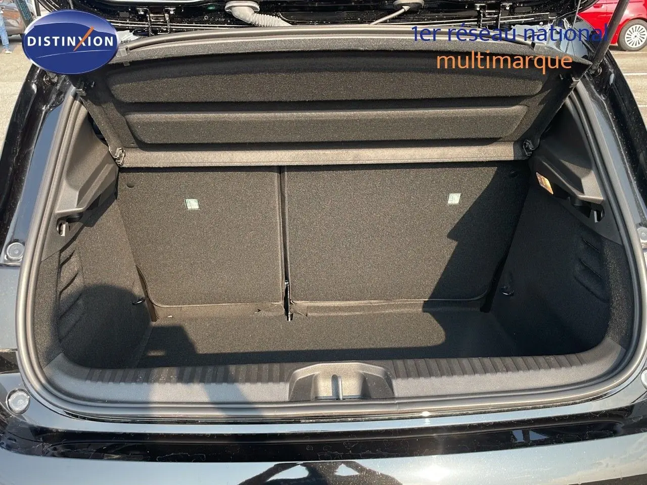 Coffre ouvert vu de l'arrière d'une Renault Clio 1.5 DCI noire étoile métal, montrant l'espace de chargement vide.