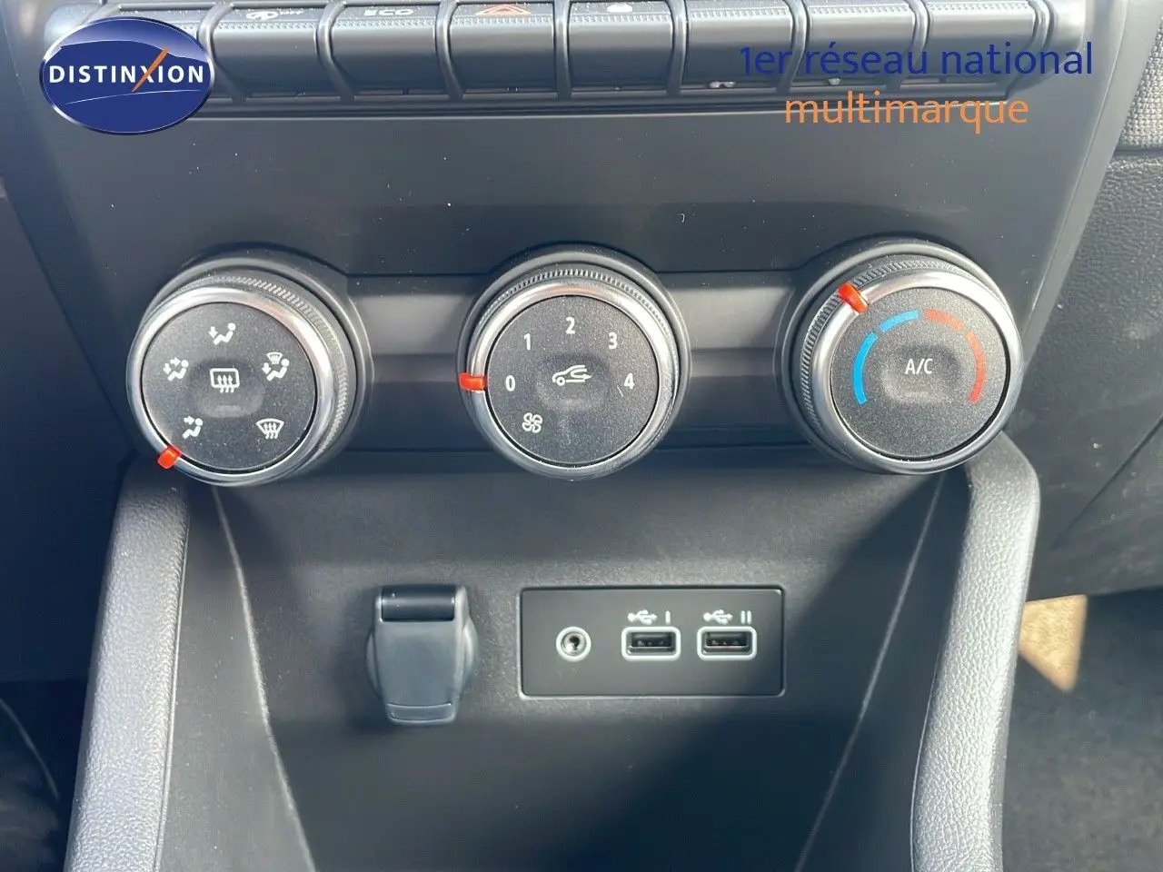 Commandes de climatisation et deux ports USB sur la console centrale d'une Renault Clio noire étoile métal 2025.