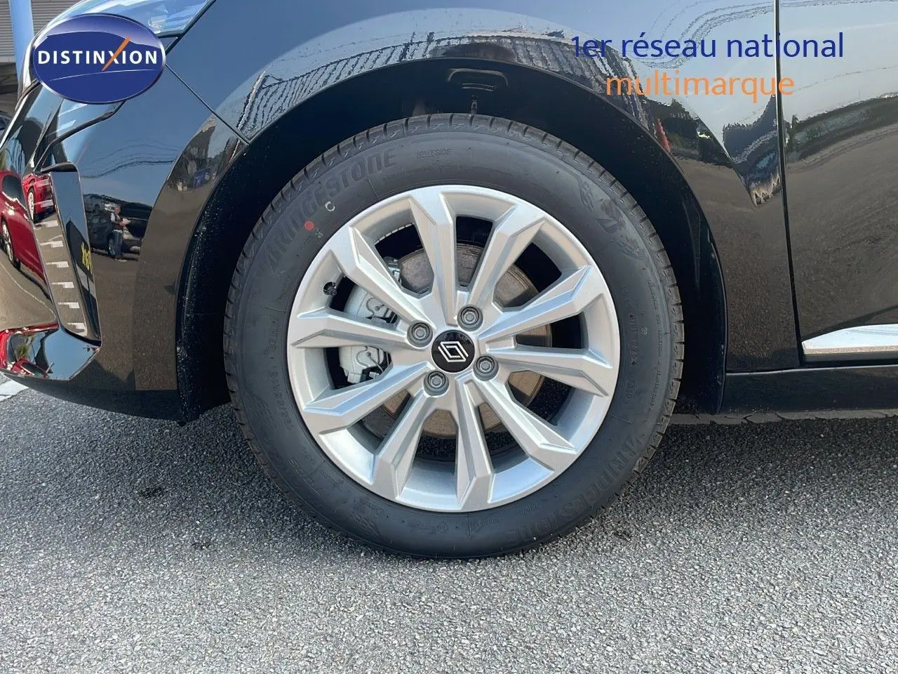 Gros plan sur la roue avant gauche d'une Renault Clio noire étoile métal avec jante alliage 16 pouces.