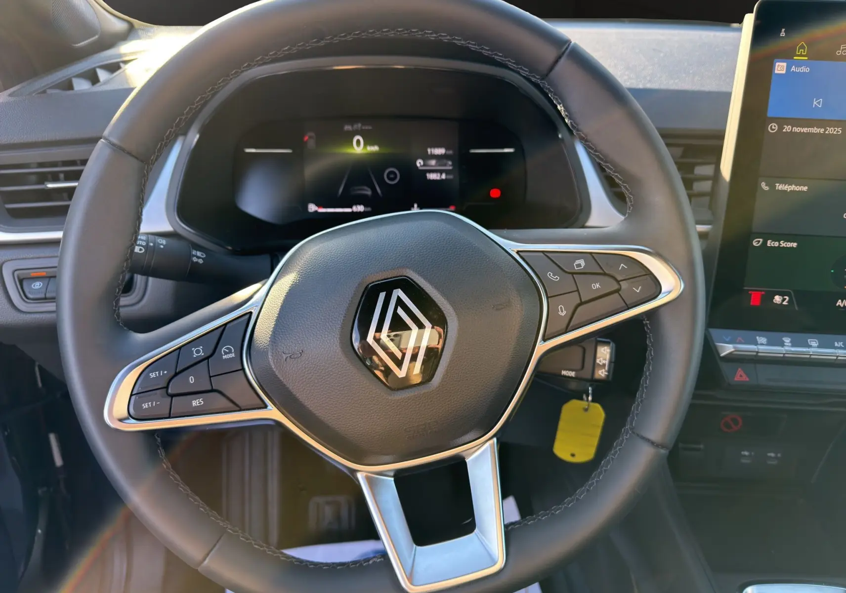 Vue intérieure centrée sur le volant du Renault Captur 2024, avec commandes intégrées et tableau de bord digital.