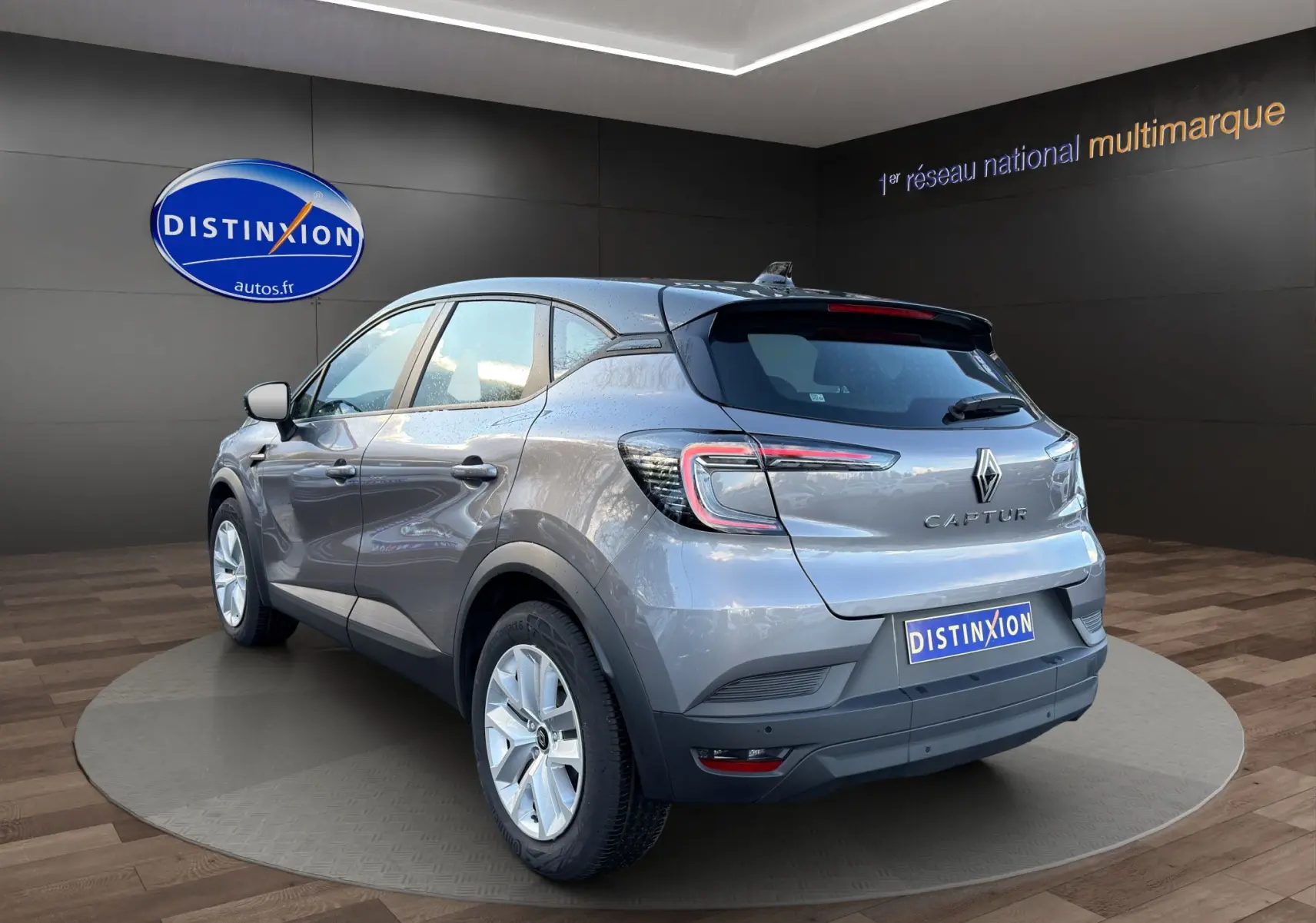 Vue 3/4 arrière droite du Renault Captur 2024 gris Cassiopée avec toit noir et caméra de recul visible.
