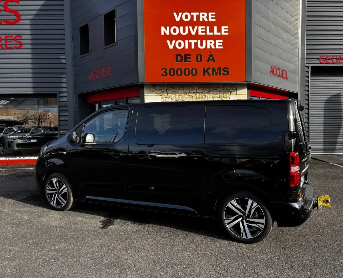 FIAT Scudo Fourgon noir vu de profil côté gauche, avec jantes alliage et attelage arrière visible.