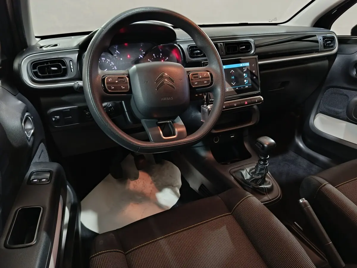 Intérieur noir de la Citroën C3 2024, vue de face sur le volant multifonctions et la console tactile centrale.