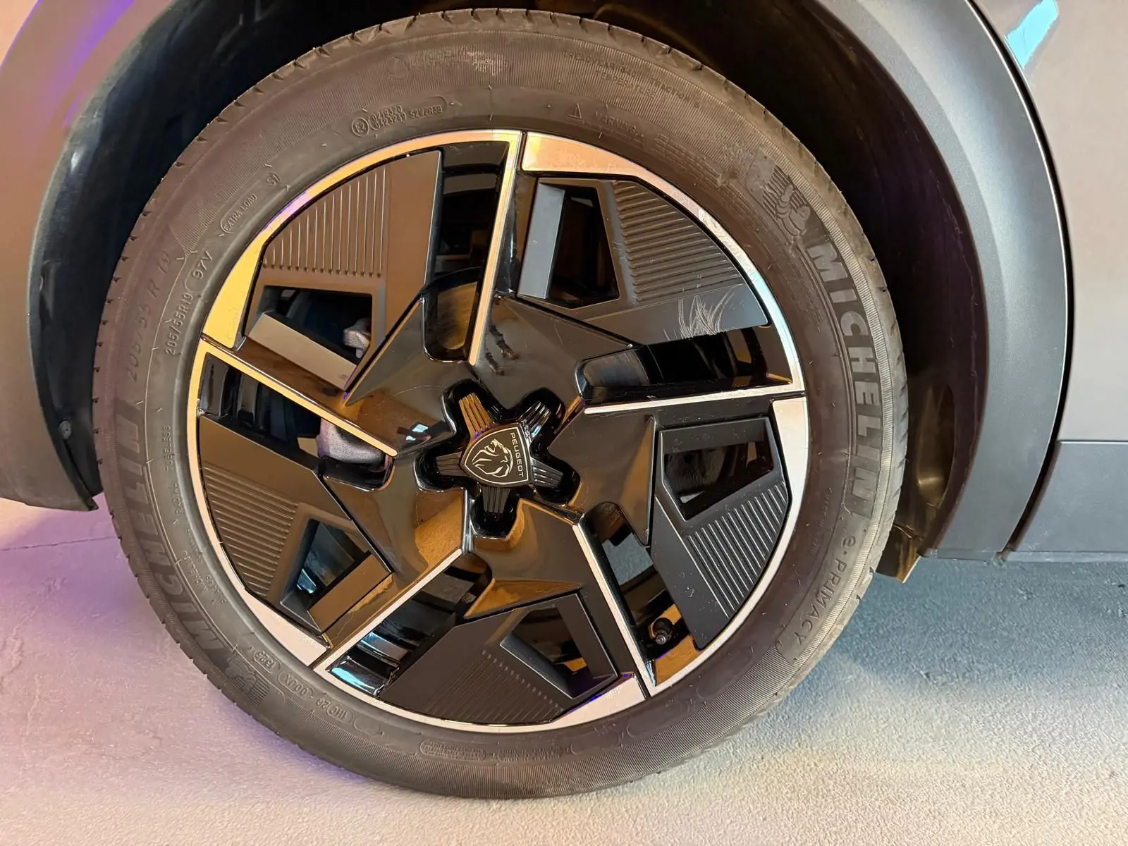 Gros plan sur la jante alliage 19'' diamantée graphite du Peugeot 408 gris, avec logo lion au centre.