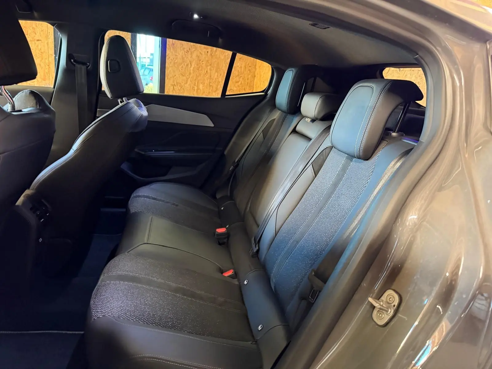 Vue intérieure côté droit des sièges arrière en tissu et cuir noir de la Peugeot 408 gris métallisé 2025.