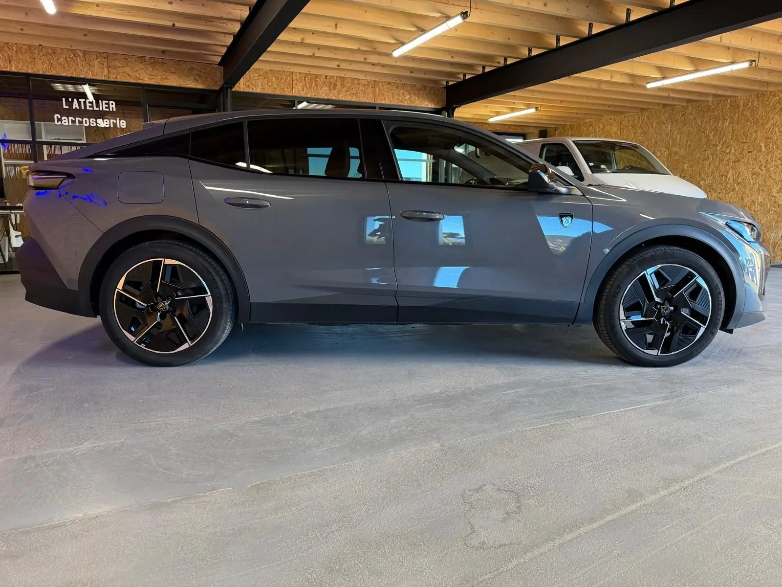 Vue latérale droite d'une Peugeot 408 gris Selenium avec jantes 19'' diamantées graphite et toit noir Mistral.