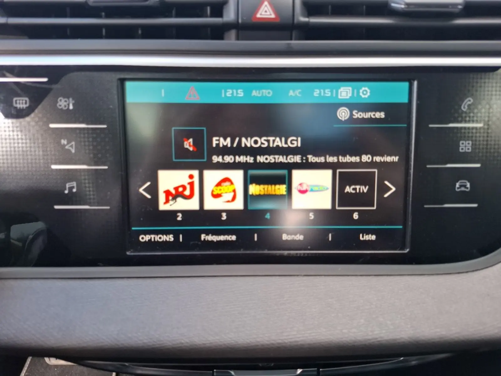 Écran tactile central du tableau de bord de la Citroën C4 Picasso 2018 affichant la radio FM Nostalgie.