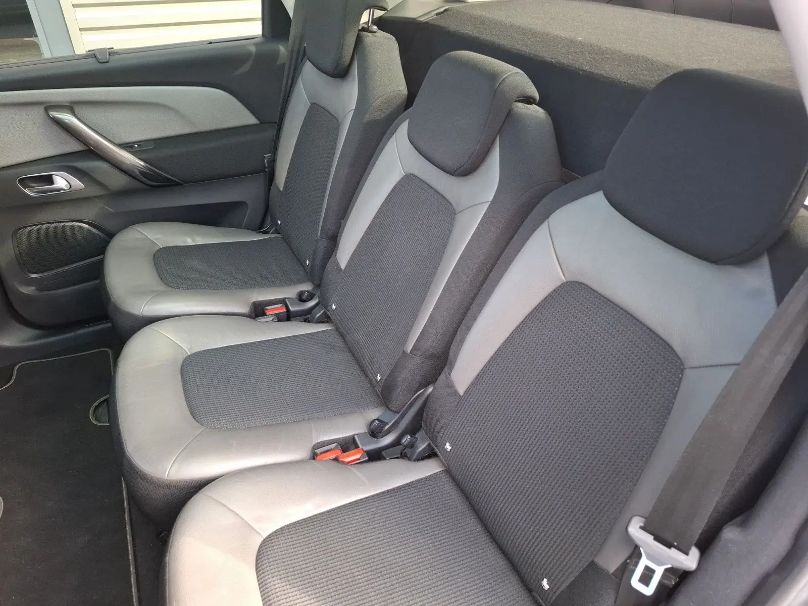 Vue latérale droite des sièges arrière cuir et tissu gris clair du Citroën C4 Picasso 2018 avec appuie-têtes intégrés.