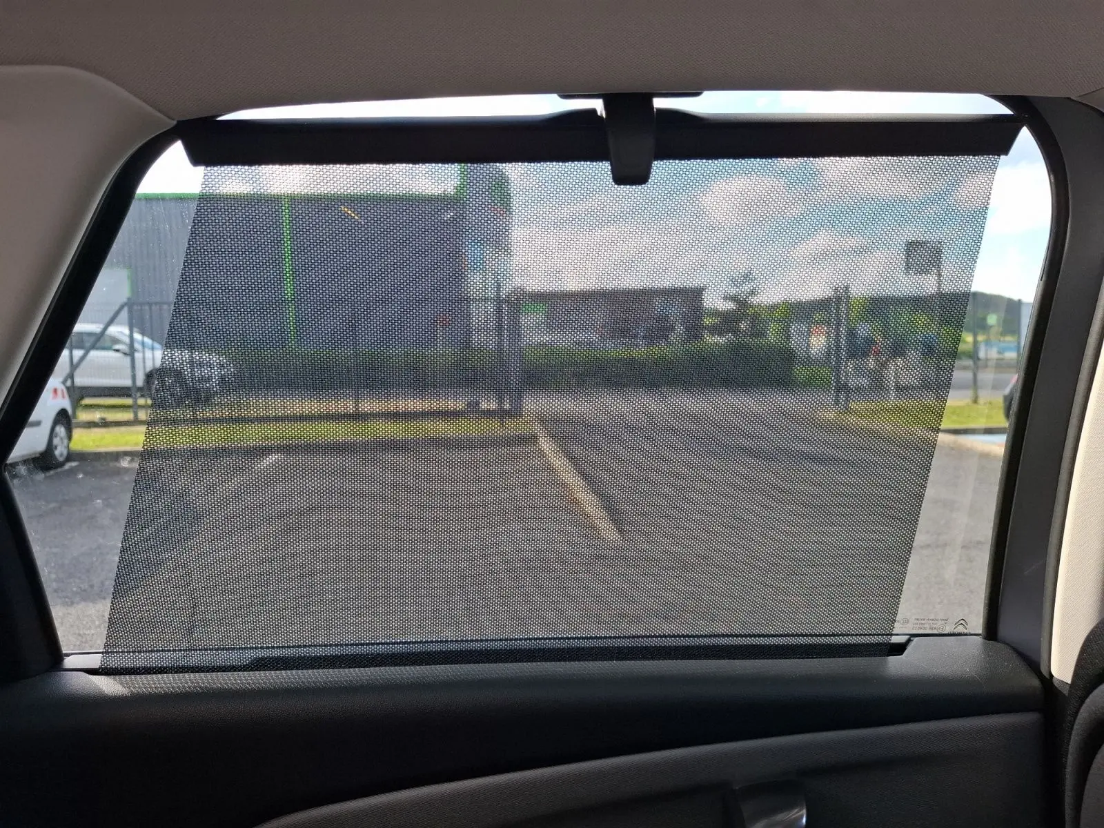 Vue intérieure sur le rideau pare-soleil de la vitre arrière côté droit du Citroën C4 Picasso gris clair 2018.