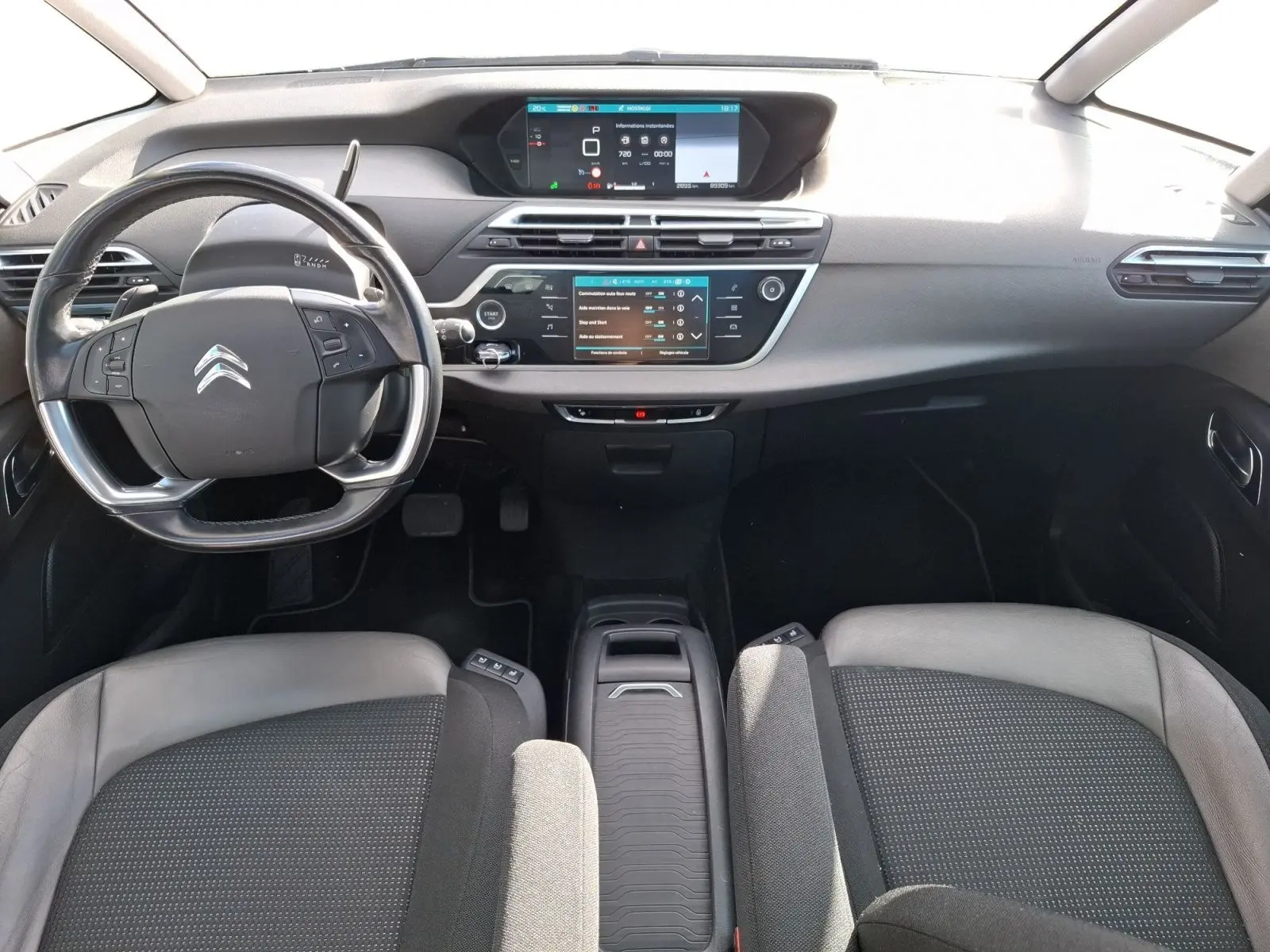 Vue intérieure avant du Citroën C4 Picasso 2018, tableau de bord gris avec écran tactile et volant multifonction.