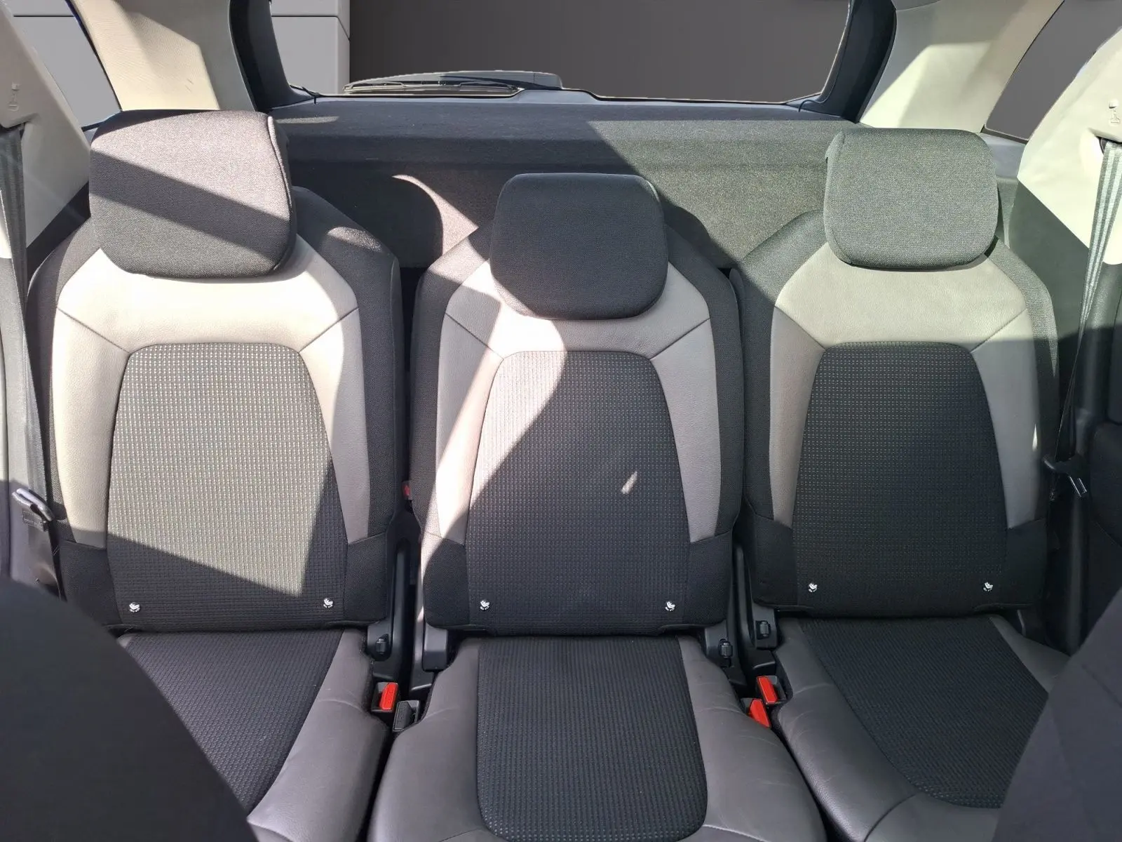Vue intérieure sur les trois sièges arrière cuir et tissu gris clair du Citroën C4 Picasso 2018, avec appuie-têtes intégrés.