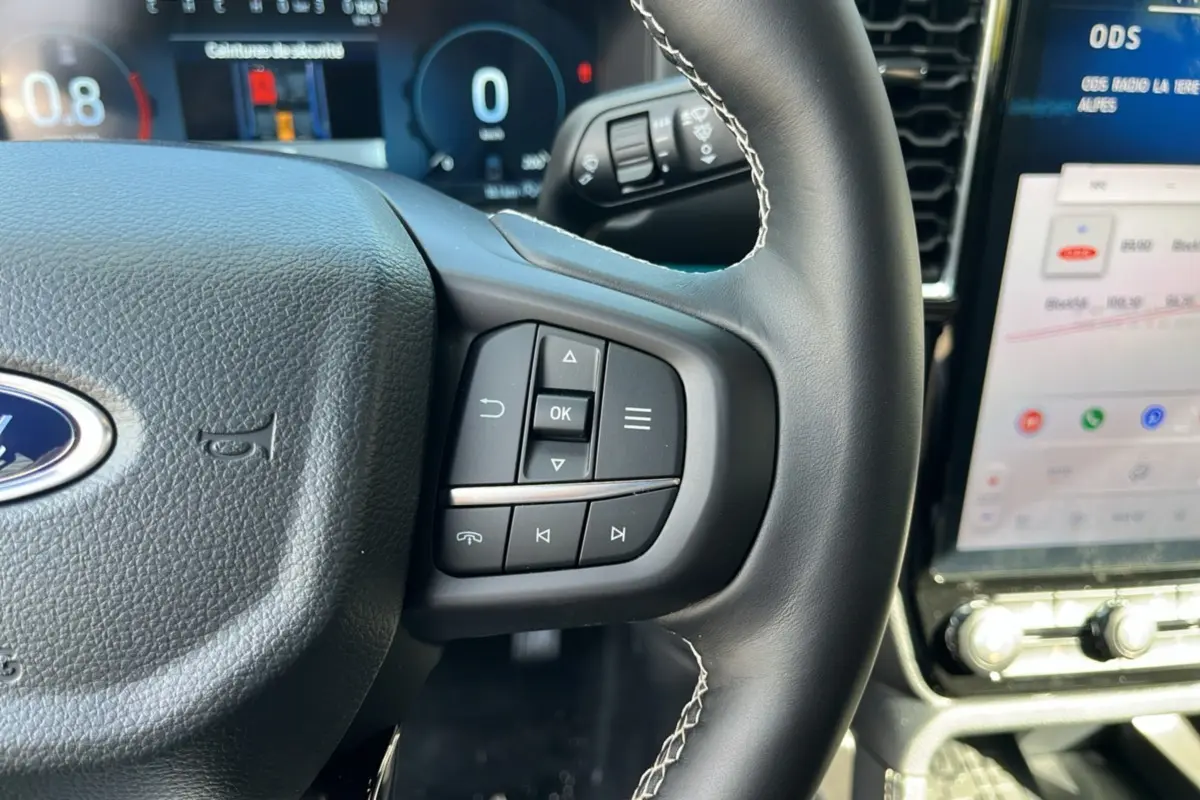 Gros plan sur le volant cuir multifonctions du Ford Ranger 2026 avec commandes intégrées et tableau de bord numérique.