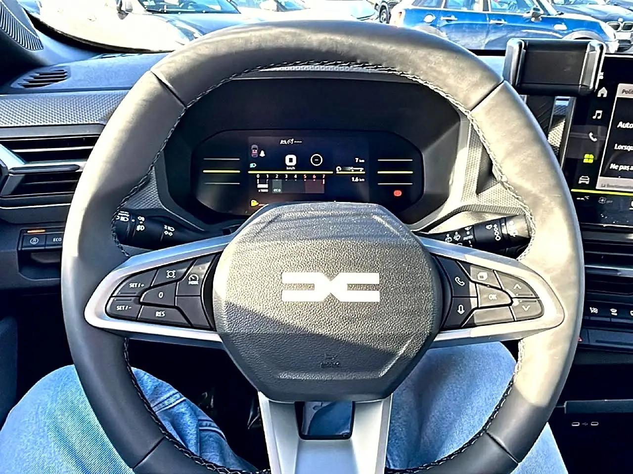 Vue rapprochée du volant noir multifonction et du tableau de bord numérique du Dacia Duster 2026.