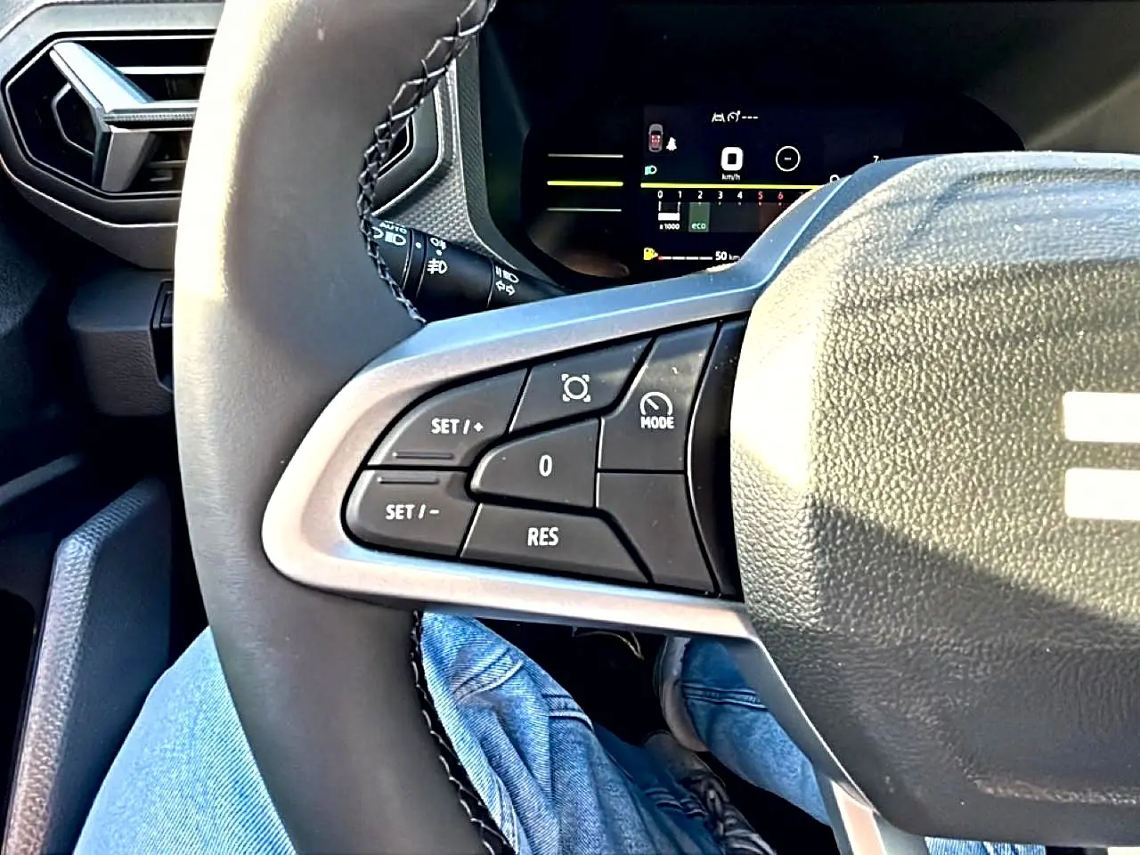 Gros plan sur le volant multifonction noir du Dacia Duster 2026, avec commandes de régulateur de vitesse visibles côté gauche.