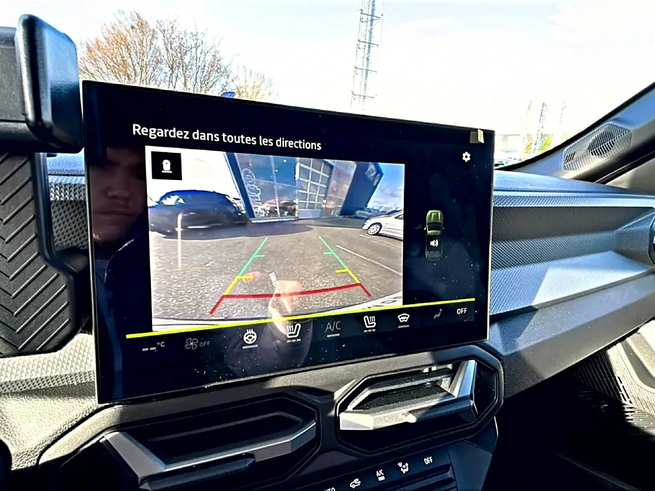 Écran tactile intérieur du Dacia Duster 2026 montrant la caméra de recul, avec tableau de bord et aérateurs noirs.