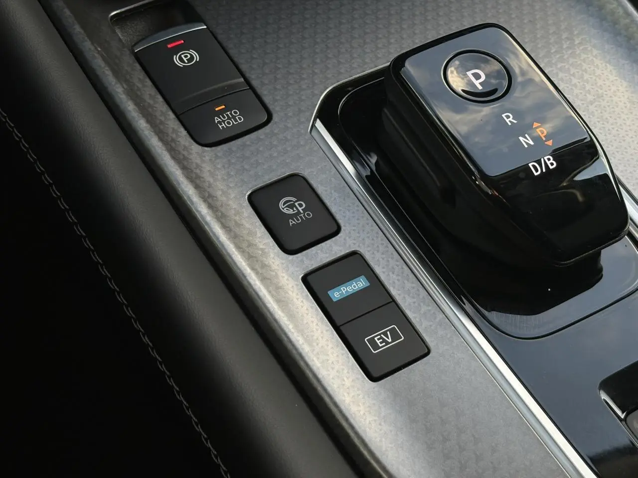 Gros plan sur la console centrale noire et grise du Nissan Qashqai 2026 avec sélecteur de boîte auto et boutons e-Pedal et EV.