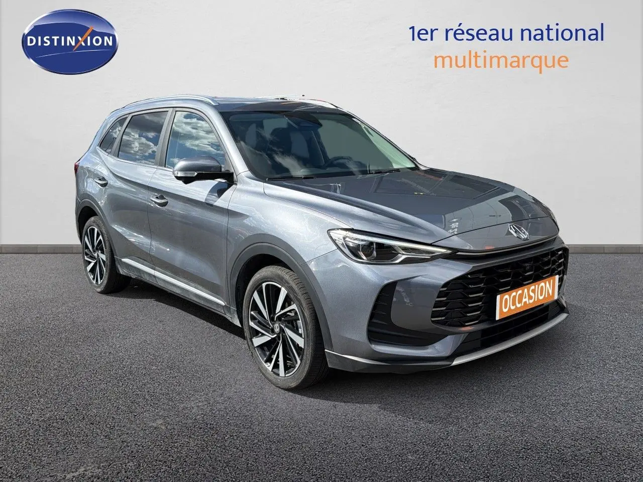 MG ZS 1.5L Hybrid+ 2025 en gris Hampstead, vue 3/4 avant avec calandre noire et jantes bi-ton.
