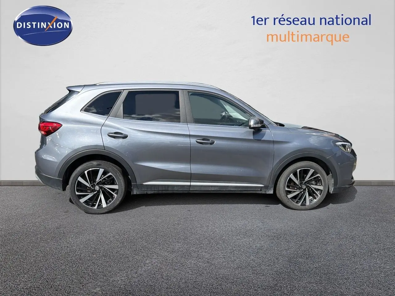 Vue de profil côté gauche du MG ZS 1.5L Hybrid+ 197ch Luxury en gris métallisé Hampstead, avec jantes alliage bicolores.