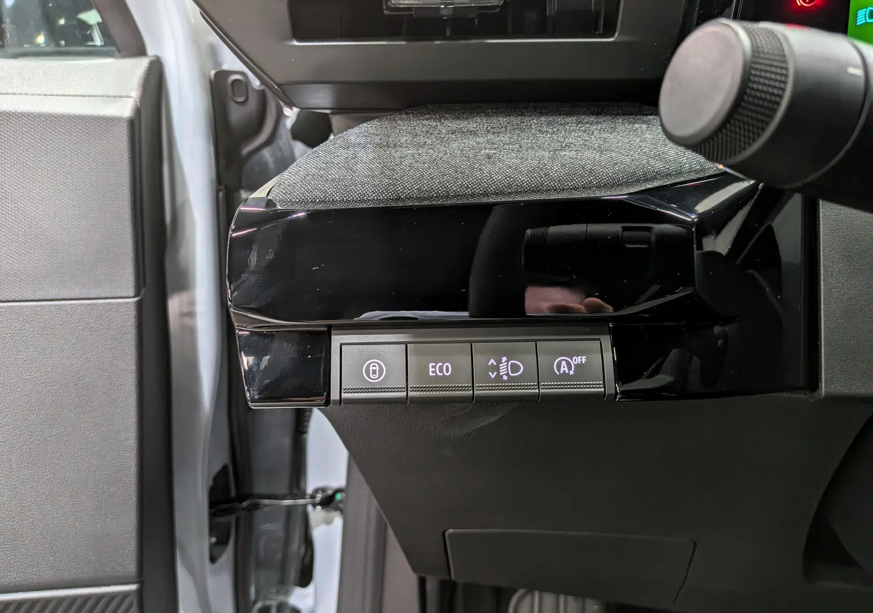 Vue rapprochée côté gauche du tableau de bord gris et noir de la Renault Clio VI avec boutons de contrôle éclairés.