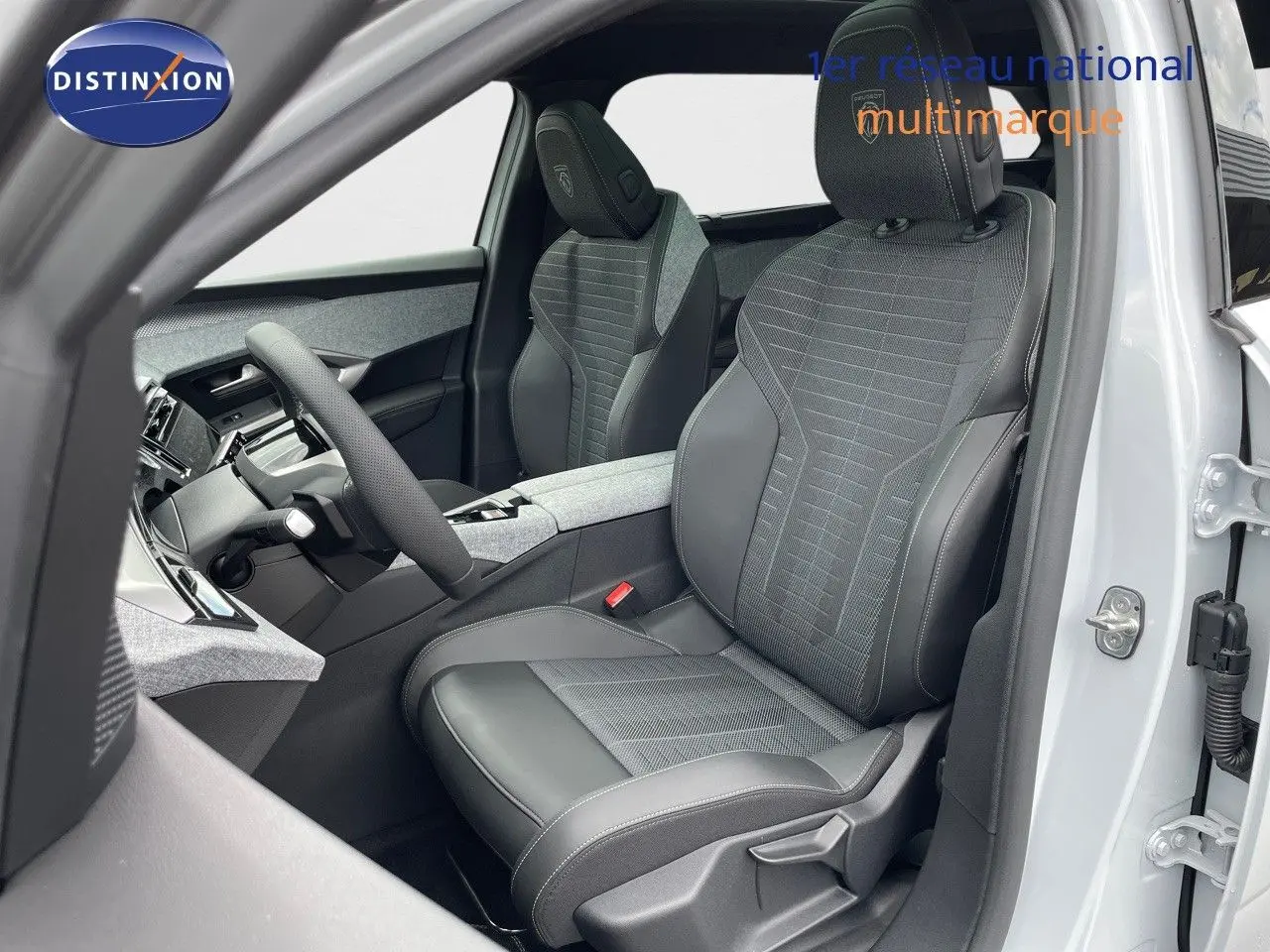 Vue intérieure côté conducteur du Peugeot 5008 Hybrid 2025 avec sièges gris en tissu et cuir contrasté.
