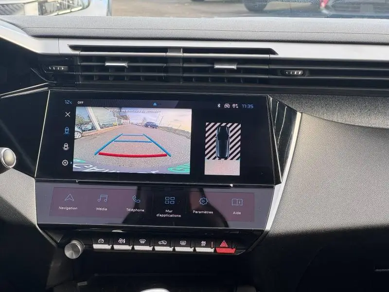 Vue intérieure du tableau de bord de la Peugeot 308 2024, écran tactile affichant la caméra de recul et les commandes multimédia.