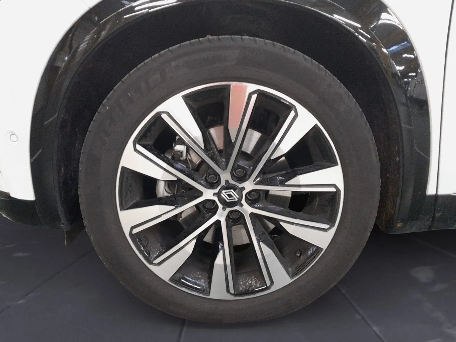 Gros plan sur la jante alliage 19'' diamantée noir et argent du Renault Espace blanc nacré côté avant droit.