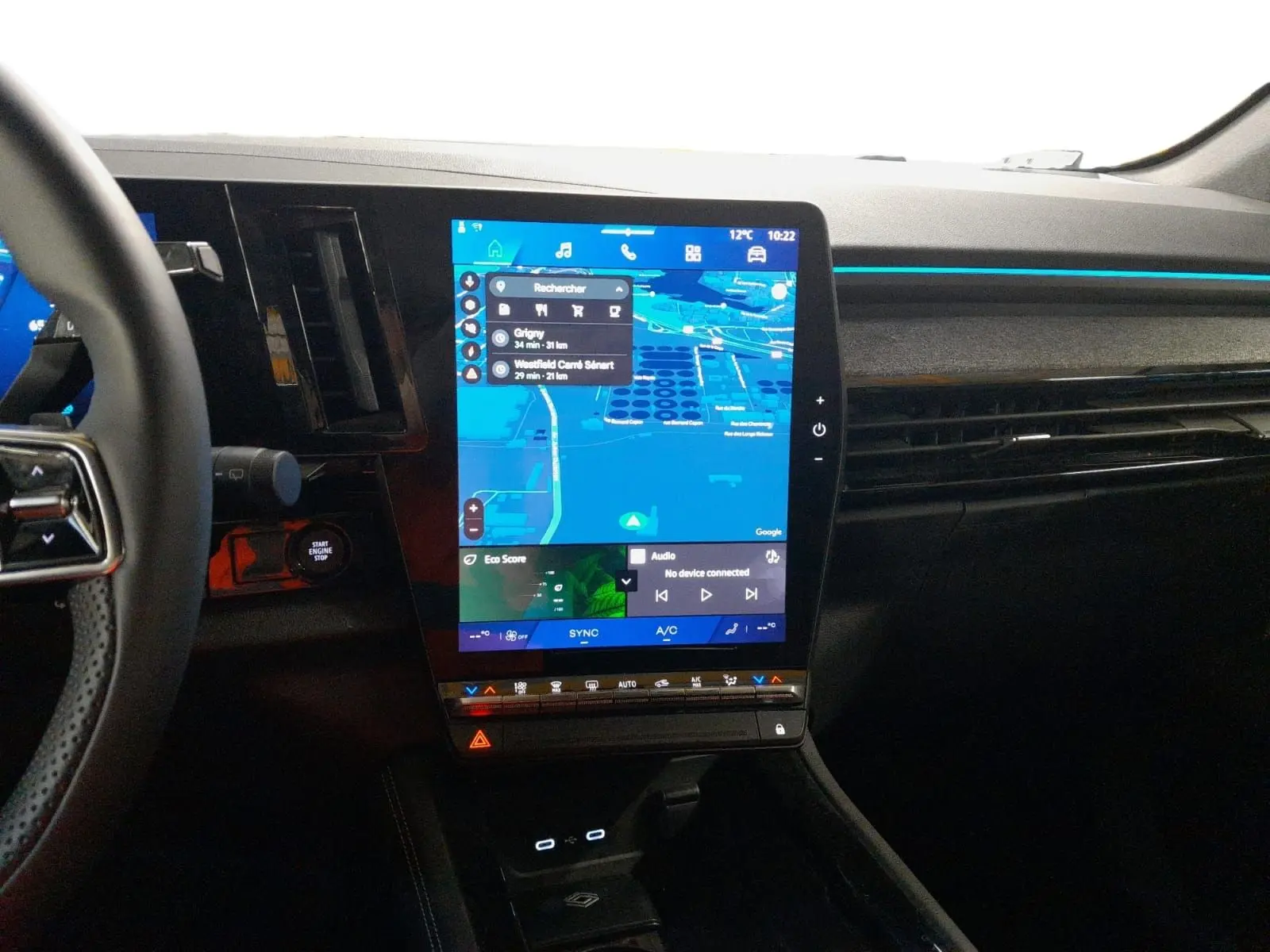 Vue intérieure du tableau de bord du Renault Espace 2025 avec écran tactile vertical et ambiance lumineuse bleue.