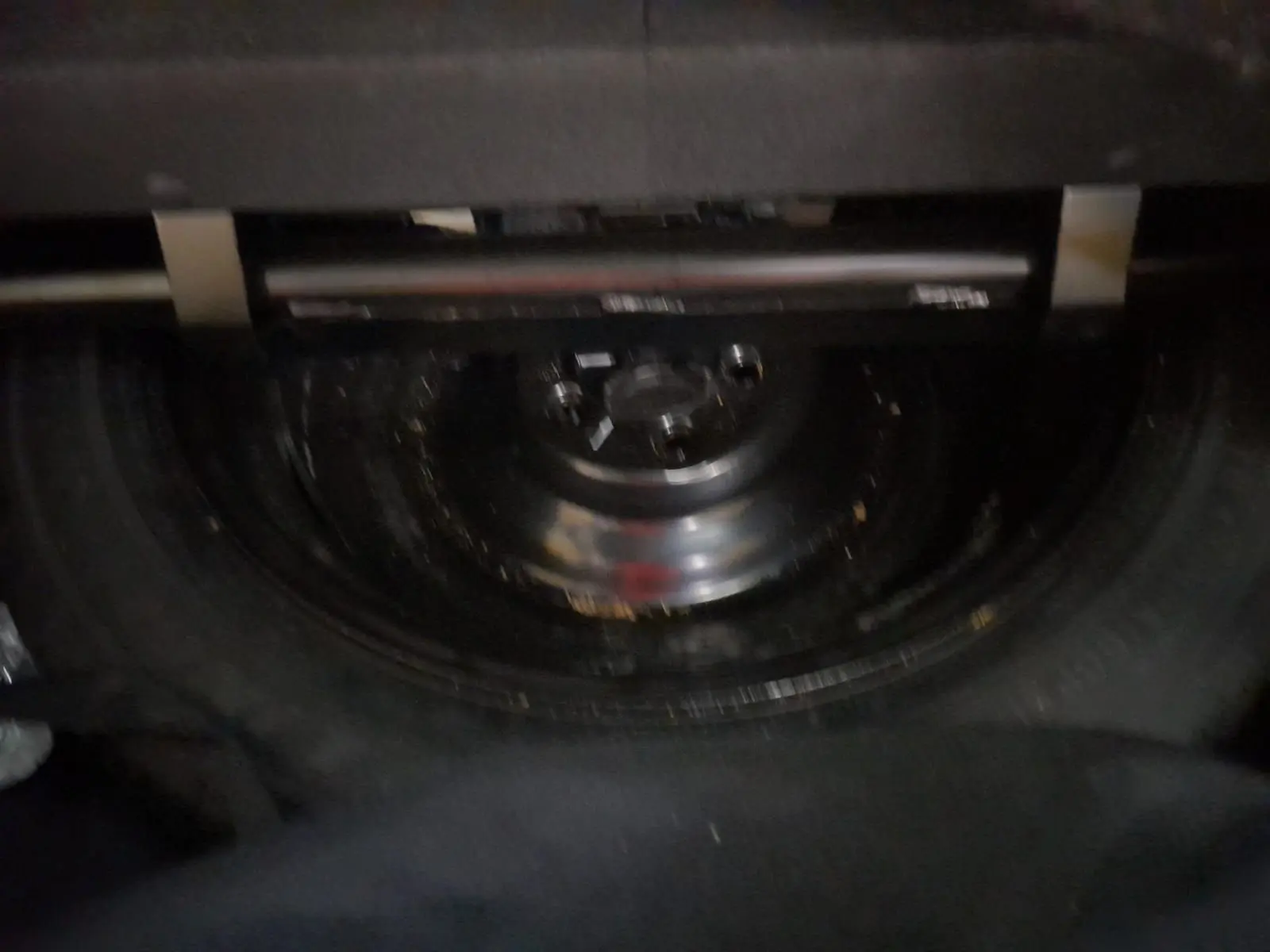 Gros plan sur la roue de secours sous le coffre du Renault Espace blanc nacré, version hybride 7 places 2025.