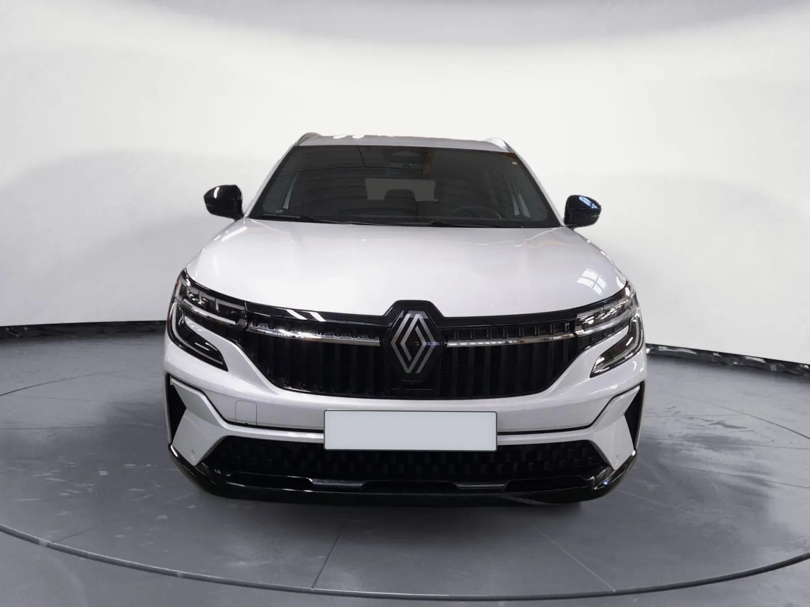 Vue frontale du Renault Espace blanc nacré 2025 avec calandre noire et feux LED adaptatifs.