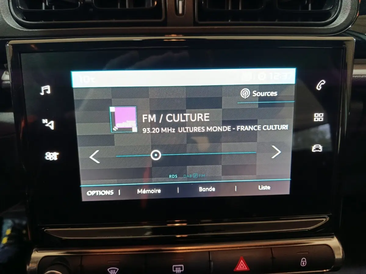 Écran tactile central de la Citroën C3 2024 affichant la radio FM sur fond noir brillant.