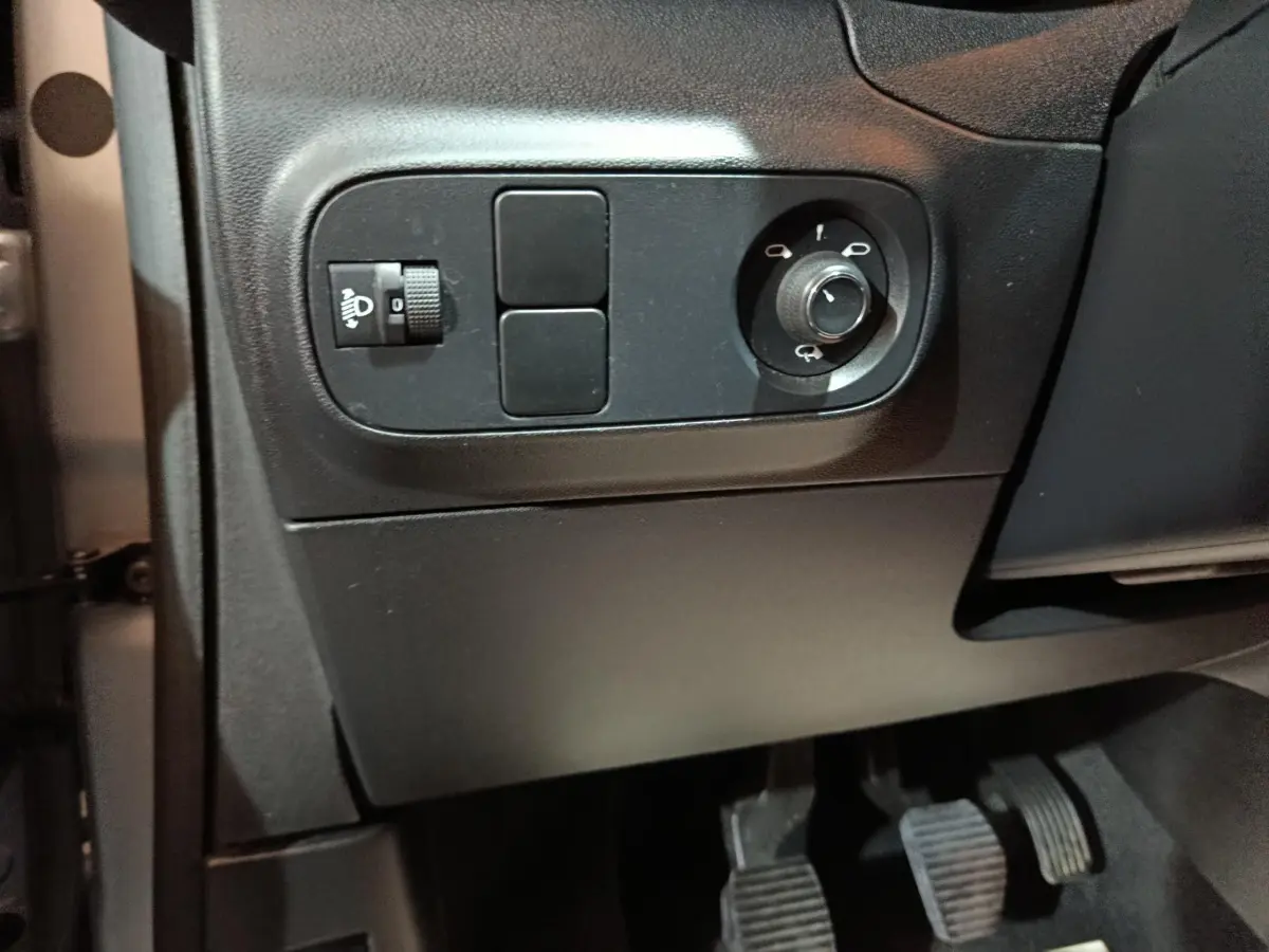 Détail du panneau de réglage des phares et des rétroviseurs côté conducteur dans l’habitacle gris foncé d’une Citroën C3 2024.