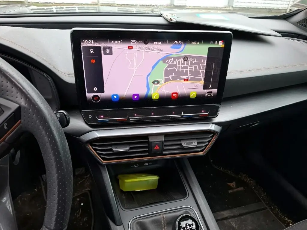 Vue intérieure du tableau de bord du CUPRA Formentor noir, mettant en valeur l'écran tactile central avec navigation et les finitions cuivrées.