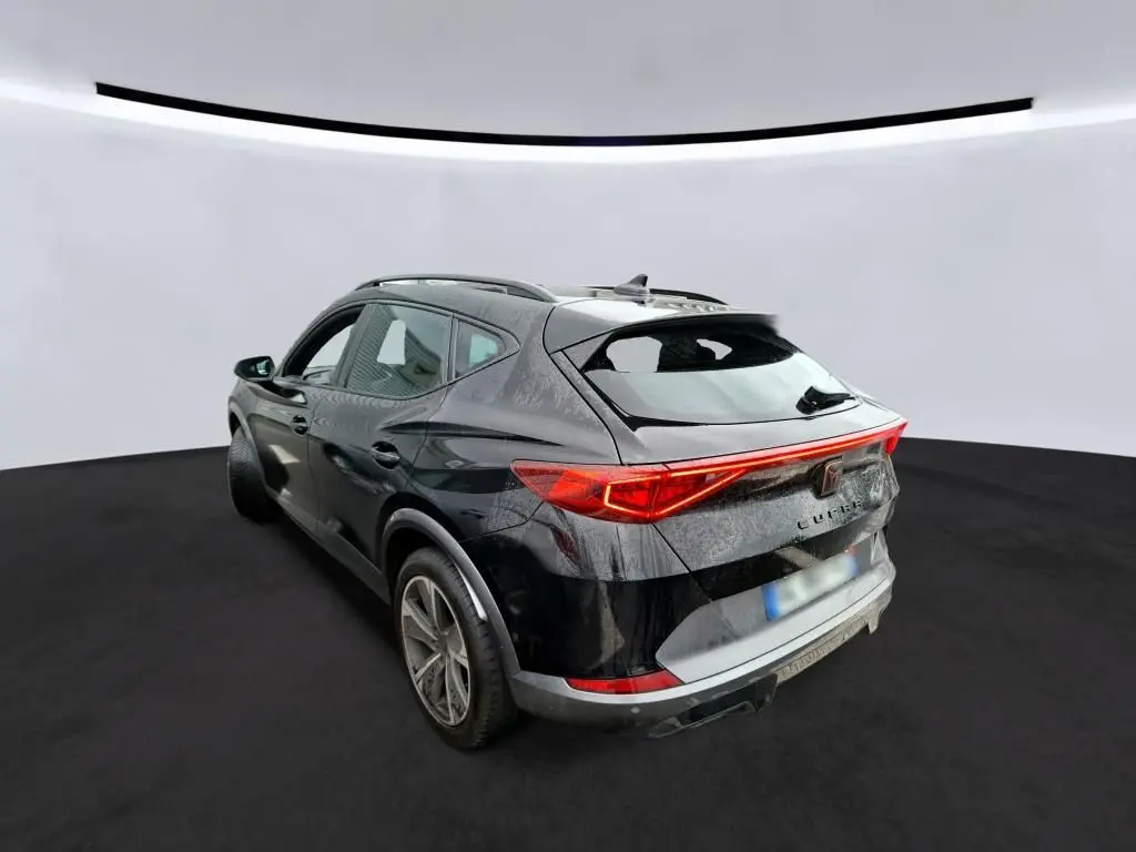 Vue 3/4 arrière droite d'un CUPRA Formentor noir 2022 avec signature lumineuse arrière en bandeau LED rouge.