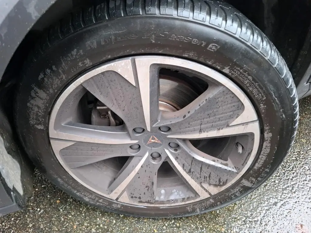 Gros plan sur la jante alu grise à cinq branches du côté gauche d'une CUPRA Formentor noire avec logo central cuivré.