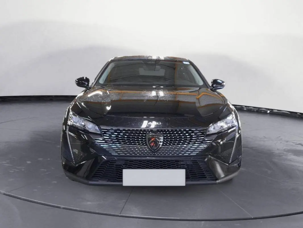 Vue frontale d'une Peugeot 408 PHEV 180 e-EAT8 Allure noire, avec calandre distinctive et phares LED fins.