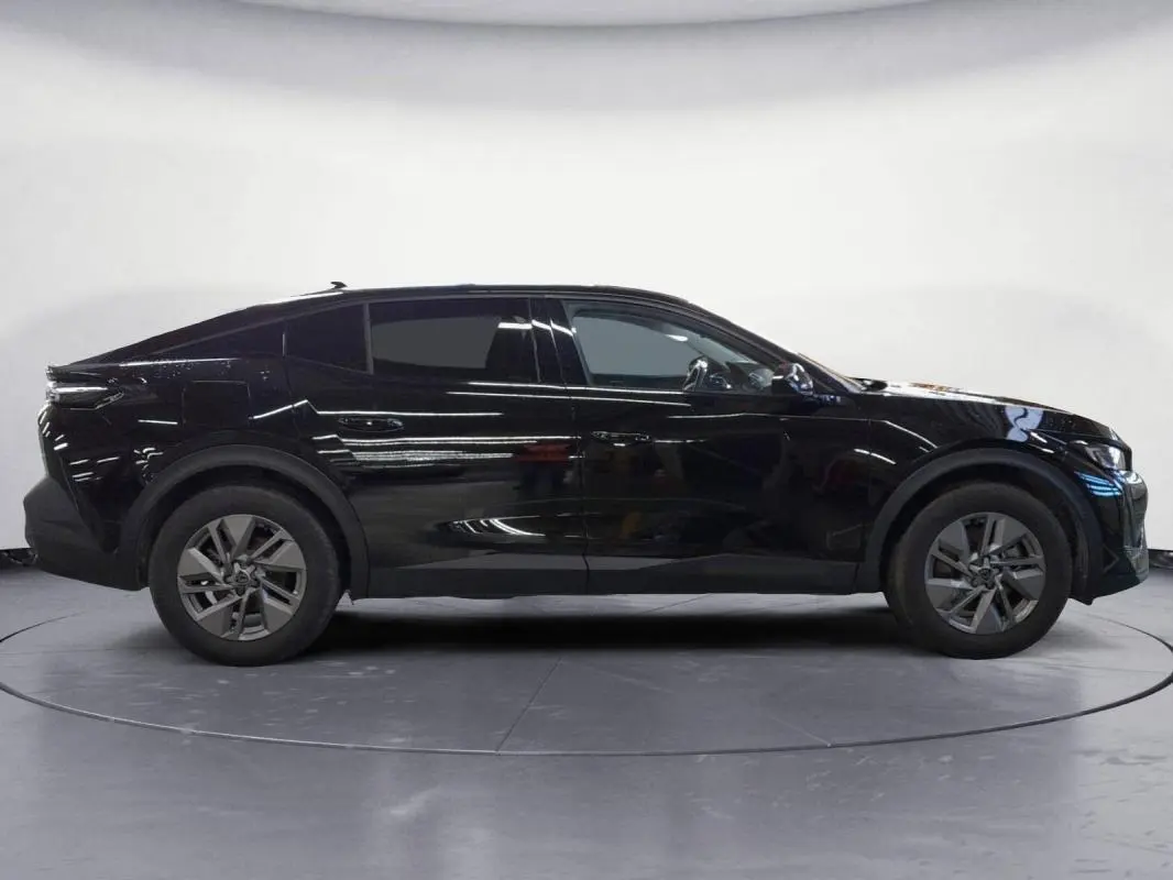 Peugeot 408 PHEV noir vue de profil côté gauche, avec jantes alliage 17 pouces et lignes dynamiques marquées.