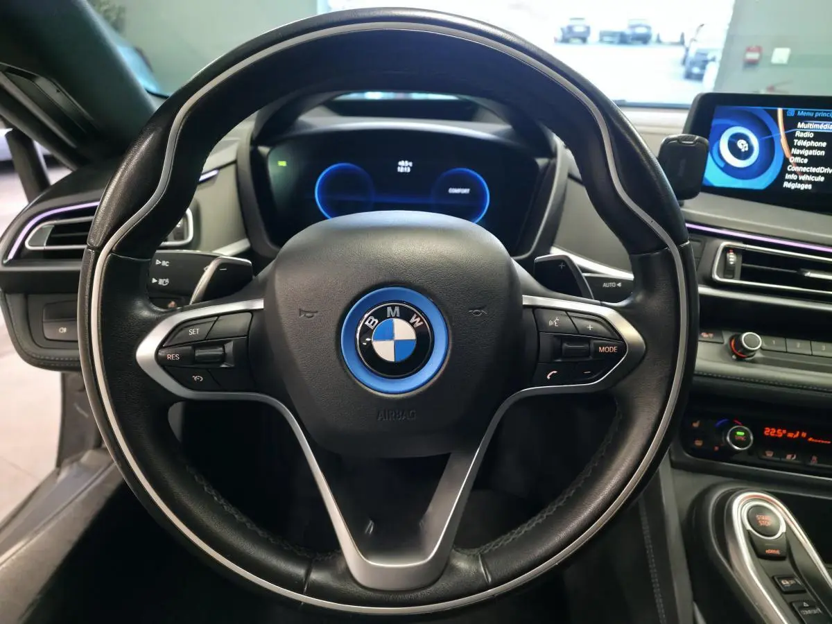 Vue rapprochée du volant cuir noir de la BMW i8 Pure Impulse 2015 avec tableau de bord numérique et écran central.