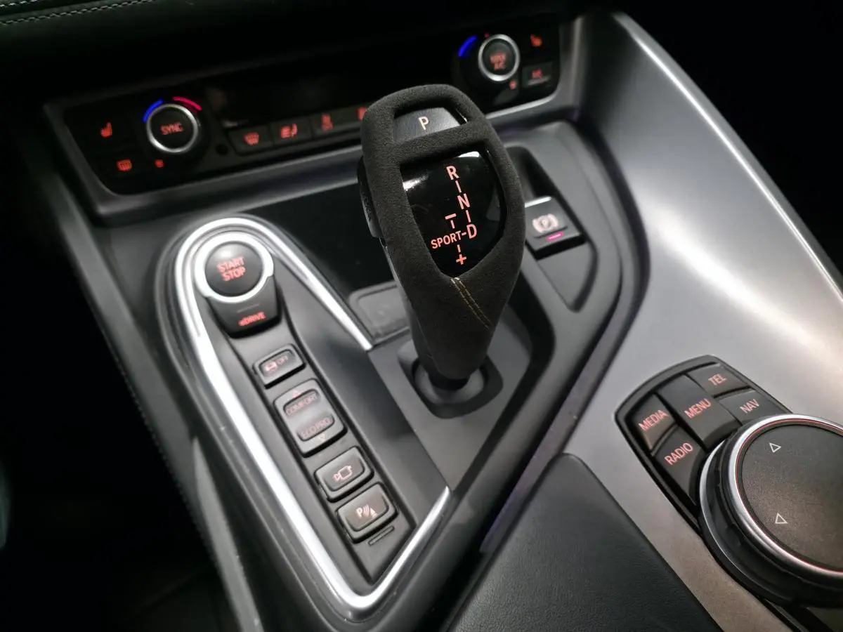 Gros plan sur la console centrale noire du BMW i8 Coupé Pure Impulse avec levier de vitesses en alcantara et commandes de mode de conduite.