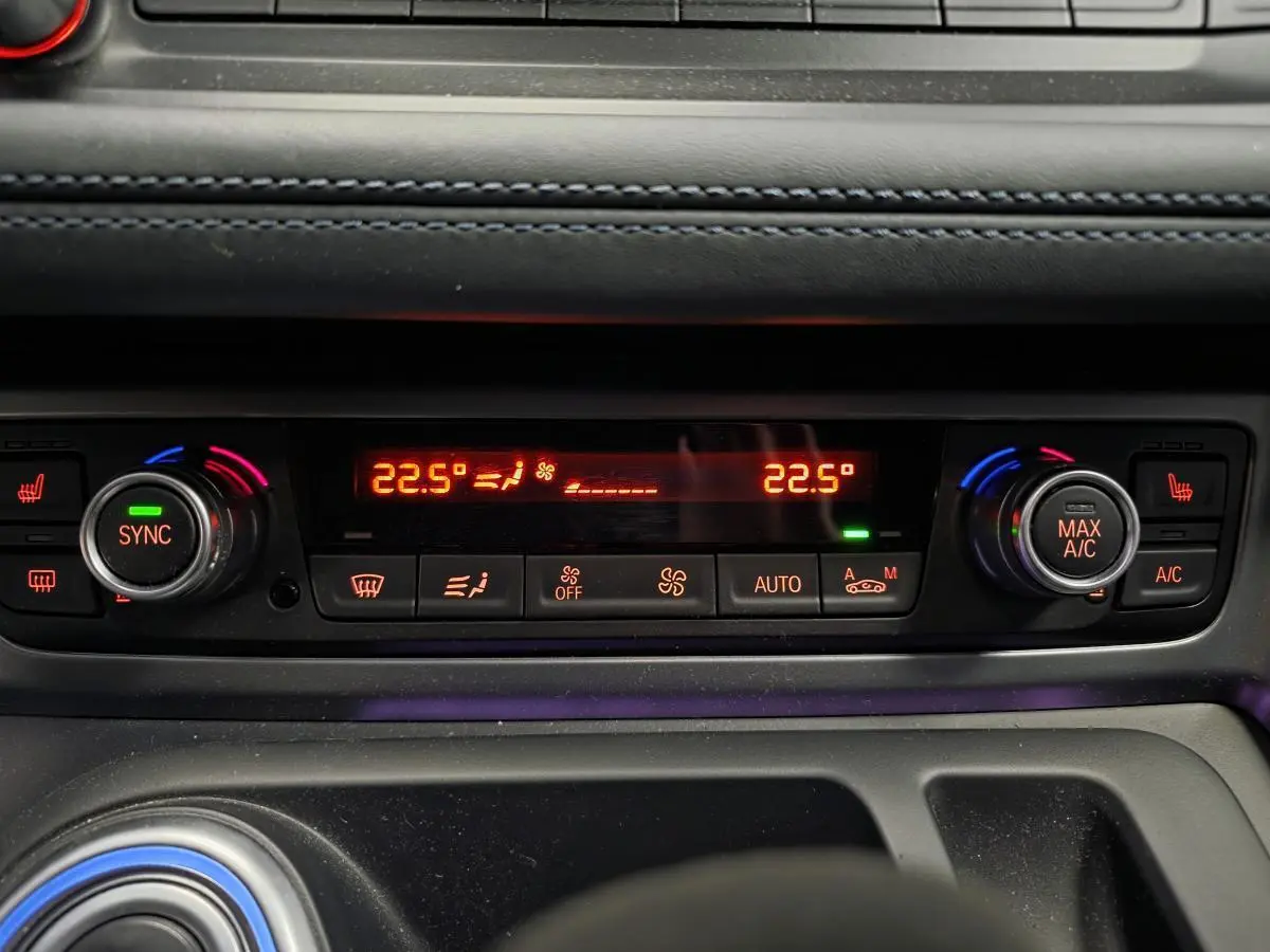Détail de la console centrale de la BMW i8 noire, affichant la climatisation automatique à 22,5°C avec commandes rétroéclairées.