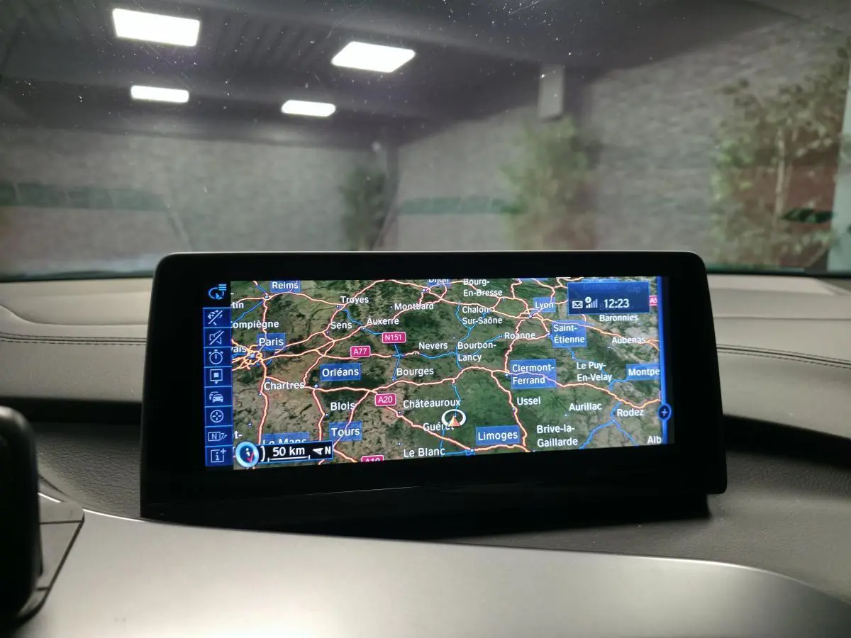 Écran de navigation multimédia affichant une carte routière dans l'habitacle d'une BMW i8 noire.