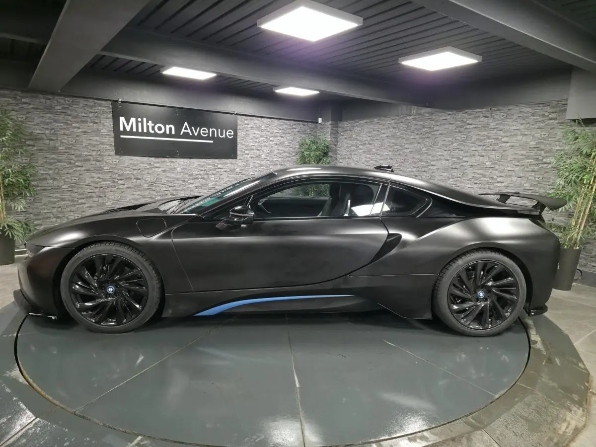 BMW i8 Coupé Pure Impulse noir mat vue de profil côté gauche avec jantes noires et spoiler arrière.