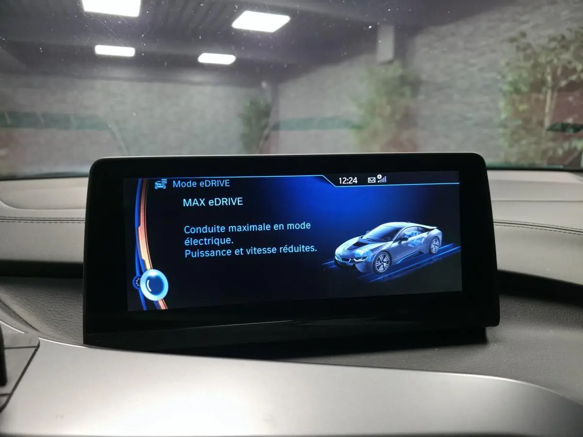 Écran central intérieur affichant le mode eDrive avec illustration d'une BMW i8 en bleu sur fond noir.