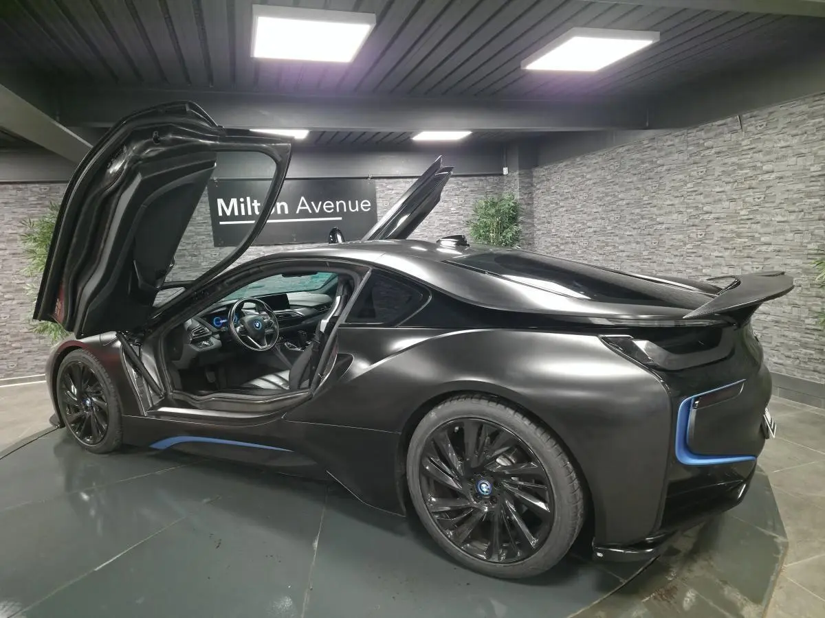 BMW i8 Coupé Pure Impulse noir mat vue 3/4 arrière droit avec portes en élytre ouvertes et jantes 20 pouces.