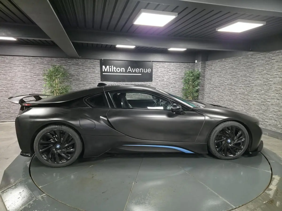 BMW i8 Coupé Pure Impulse noir mat, vue de profil côté gauche avec jantes turbine 20 pouces et détails bleus.