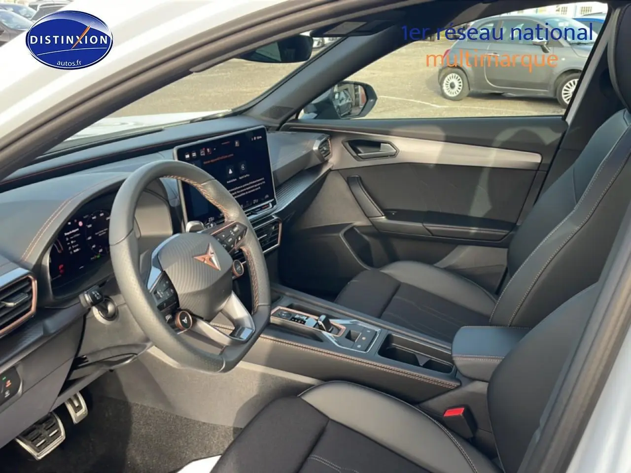 Vue intérieure côté conducteur de la CUPRA Formentor blanc Nevada, avec volant cuir sport et écran tactile central.