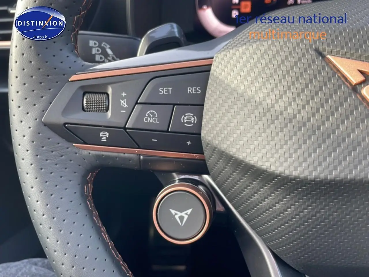 Gros plan sur le volant sport perforé de la CUPRA Formentor blanc Nevada avec commandes multifonctions et détails cuivrés.